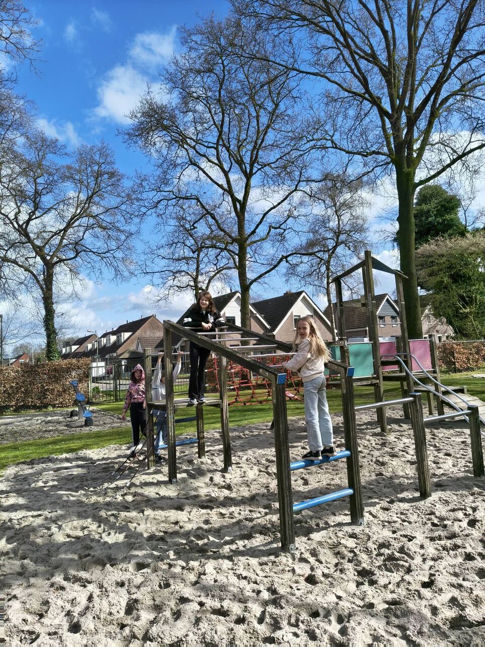 Kinderen klimmen op het houten klimtoestel in de speeltuin